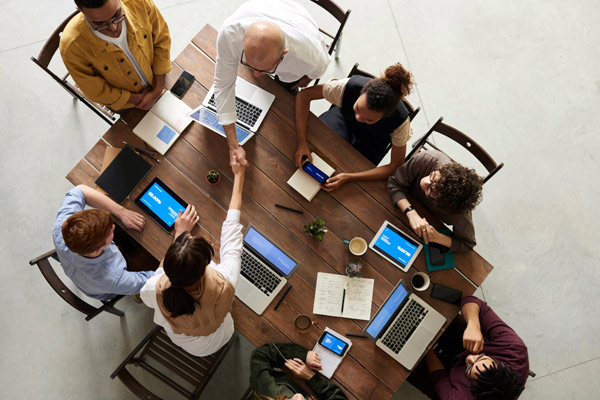 Business people shaking hands across a table.